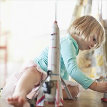 Petite fille jouant avec des robots et une fusée