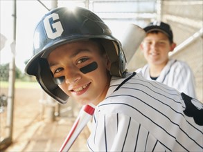 USA, California, Ladera Ranch, boys (10-11) from little league baseball team on dugout.