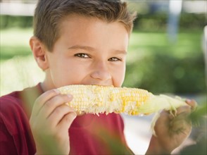 USA, New York, Flanders, Boy (8-9) eating corn. Photo : Jamie Grill Photography