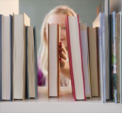 USA, New Jersey, Jersey City, Girl (8-9) arranging book. Photo : Jamie Grill Photography