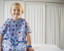 USA, New Jersey, Jersey City, Girl (8-9) sitting on hospital bed. Photo : Jamie Grill Photography