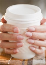 USA, New Jersey, Jersey City, Close-up view of woman's hands holding takeaway coffee. Photo : Jamie