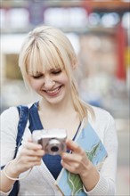USA, Seattle, Young woman checking pictures at digital camera. Photo : Take A Pix Media