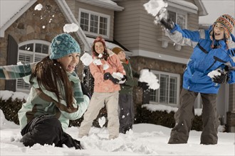 USA, Utah, Provo, Boys (10-11, 12-13) and girls (10-11, 16-17) having snow ball fight in front of
