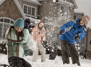 USA, Utah, Provo, Boys (10-11, 12-13) and girls (10-11, 16-17) having snow ball fight in front of