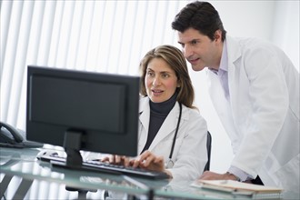 USA, New Jersey, Jersey City, Two doctors using computer in office.
