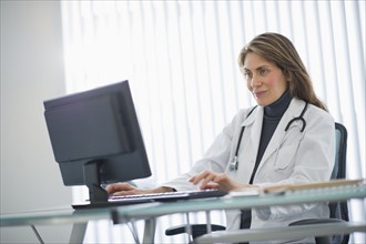 USA, New Jersey, Jersey City, Female doctor using computer in office.