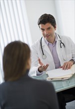 USA, New Jersey, Jersey City, Doctor talking with female patient in office.