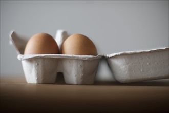 Eggs in egg carton on table, close-up.