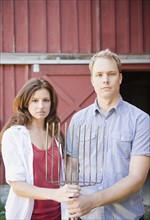 USA, New York, Flanders, Portrait of mid adult couple with pitchfork. Photo : Jamie Grill