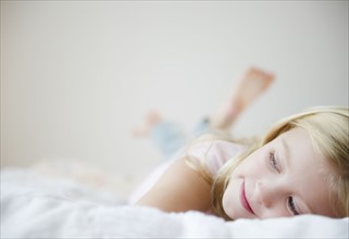 USA, New Jersey, Jersey City, Girl (8-9) laying in bed. Photo : Jamie Grill Photography