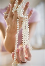 USA, New Jersey, Jersey City, Woman's hand holding pearl beads. Photo : Jamie Grill Photography
