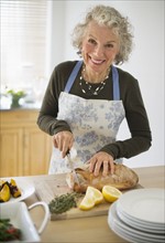 USA, New Jersey, Jersey City, Portrait of senior woman preparing food in kitchen.