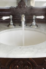 Bathroom sink with hot water running.