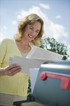 USA, New Jersey, Jersey City, Woman checking mail at mailbox.