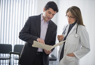 USA, New Jersey, Jersey City, Medical sales representative talking with female doctor in office.