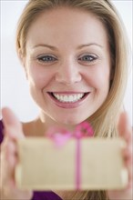 USA, New Jersey, Jersey City, Young attractive woman holding gift. Photo : Jamie Grill Photography