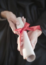 USA, New Jersey, Jersey City, Close-up view of woman hands holding diploma. Photo : Jamie Grill