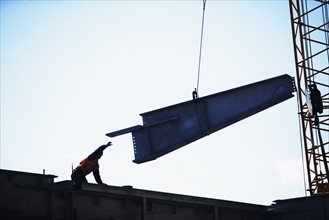 USA, New York City, girder being lifted at construction site. Photo : fotog
