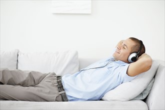 South Africa, Man relaxing while listening music. Photo : momentimages