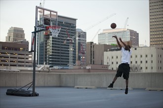 USA, Utah, Salt Lake City, young man playing basketball. Photo : Mike Kemp