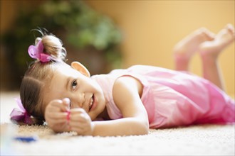 USA, Arizona, Chandler, Cute girl (2-3) wearing pink dress lying on floor. Photo : FBP