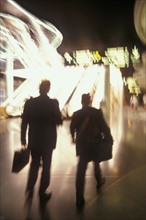 USA, Colorado, Businessmen walking through airport, blurred motion. Photo : John Kelly