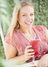 USA, New Jersey, Jersey City, Young attractive woman with pink refreshment drink. Photo : Jamie