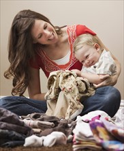 USA, Utah, Lehi, mother and son (18-23 months) folding laundry. Photo : Mike Kemp