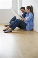 USA, New Jersey, Jersey City, Couple examining blueprints in new home .