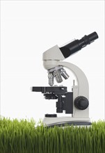 Microscope on grass in studio.