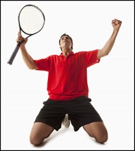 Young man playing tennis winning. Photo : Mike Kemp