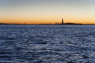 USA, New York City, Staten Island, Harbor and silhouette of Statue of Liberty in background.