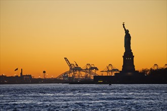 USA, New York City, Staten Island, Harbor and silhouette of Statue of Liberty in background.