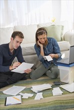 USA, New Jersey, Jersey City, Portrait of young couple doing paperwork at home.