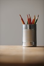 Can with pencils on table.