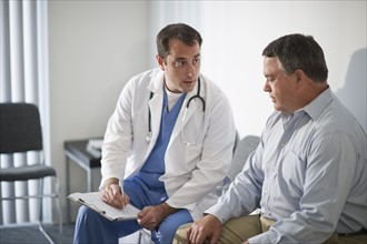 USA, New Jersey, Jersey City, Doctor discussing medical results with male patient in hospital.