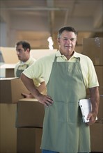 USA, New Jersey, Jersey City, Portrait of male warehouse worker by stacked boxes.