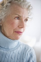Pensive senior woman smiling.