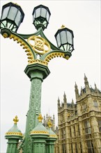 United Kingdom, London, Ornate street lamp with Houses of Parliament in background.