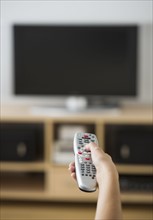 Female hand holding remote control.