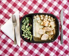Close up of TV dinner on checked table cloth. Photo : Jamie Grill Photography