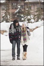 USA, Utah, Salt Lake City, couple walking in snowy village. Photo : Mike Kemp