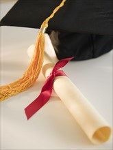 Close up of rolled diploma and mortarboard. Photo : Jamie Grill Photography
