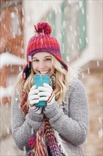 USA, Utah, Salt Lake City, portrait of young woman in winter clothing drinking. Photo : Mike Kemp