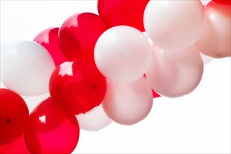 Red and white balloons on white background, studio shot.