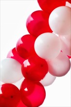 Red and white balloons on white background, studio shot.