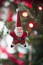 Santa Claus Christmas decoration hanging on Christmas tree, studio shot.