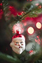 Santa Claus Christmas decoration hanging on Christmas tree, studio shot.
