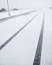 USA, New York State, Rockaway Beach, tire track in snow on road. Photo : Jamie Grill Photography